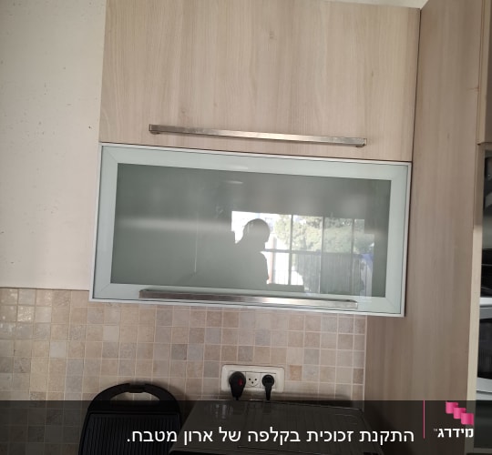 ארון מטבח עם דלת זכוכית ומכשירי חשמל